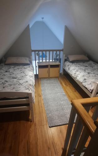 two beds in a room with wooden floors at Island View Lodge in Doolin