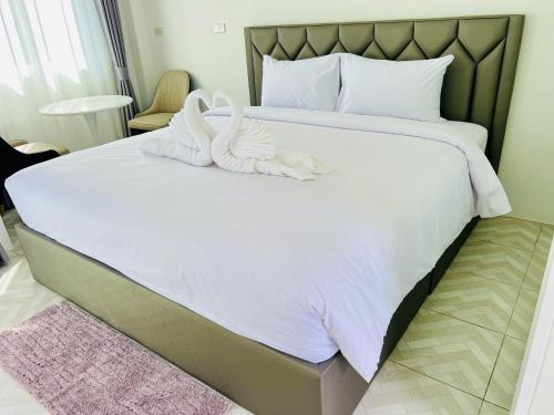a bedroom with two swans towels on a bed at Sarona House 3 in Ban Thalat Choeng Thale