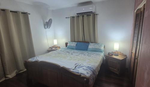 a bedroom with a bed with two night stands and two lamps at Villa Tutilia in Willemstad