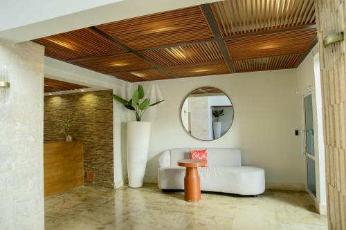 a living room with a white couch and a mirror at Stunning Beachfront 2BR Condo in Juan Dolio in Juan Dolio