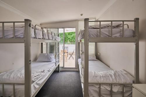 two bunk beds in a room with a window at Urban Nomad Potts Point - 18 to 39 only in Sydney