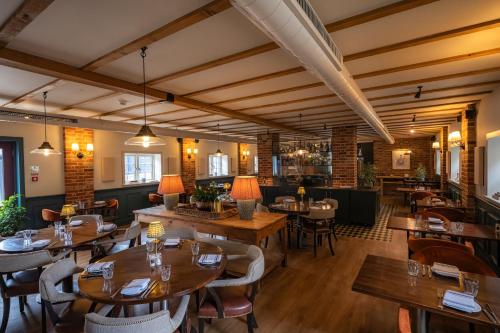 a dining room with wooden tables and chairs at Tewinbury Farm Hotel in Tewin