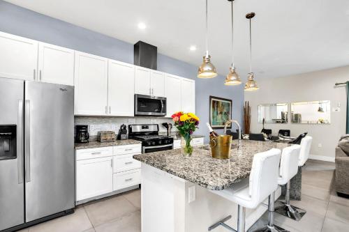 a kitchen with white cabinets and a granite counter top at 5 BR 6 BA Luxury Villa 5 min to Disneyworld Hot Tub & BBQ 112 in Orlando