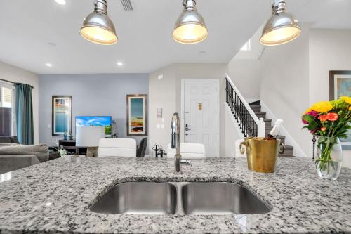 a kitchen with a sink and a living room at 5 BR 6 BA Luxury Villa 5 min to Disneyworld Hot Tub & BBQ 112 in Orlando