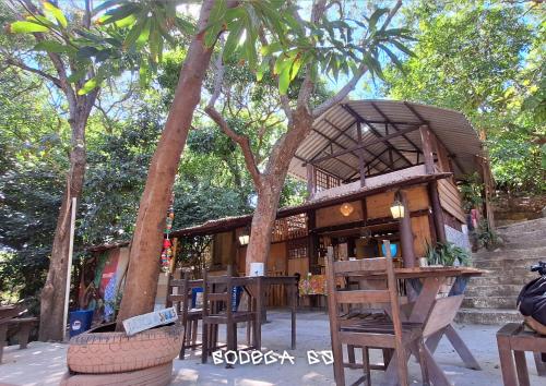 a building with a table and chairs and trees at EcoCamping da Wandinha in Cabo de Santo Agostinho