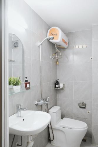 a bathroom with a white toilet and a sink at Toda House - 4Bedroom near Hoan Kiem Lake in Hanoi