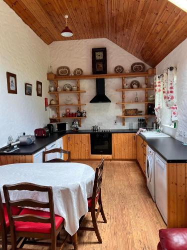 a kitchen with a table and chairs and a stove at Rural Donegal cottage near sandy beaches in Clonmany