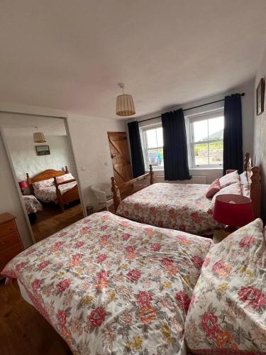 a bedroom with two beds and a mirror at Rural Donegal cottage near sandy beaches in Clonmany