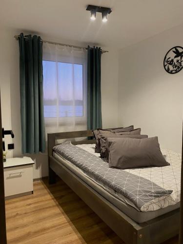 a bedroom with a bed with green curtains and a window at Zacisze nad wodą in Strzegocice