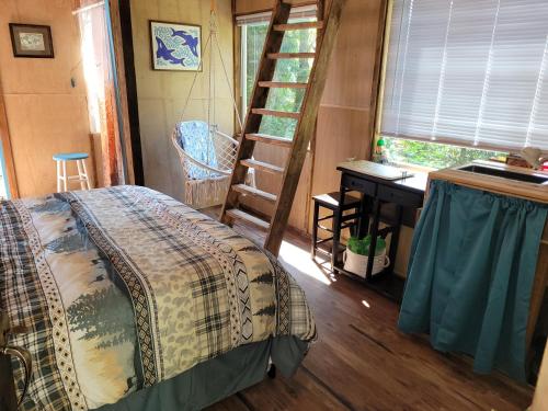 a bedroom with a bed and a desk in a tiny house at Moss Haven on Hood Canal in Quilcene