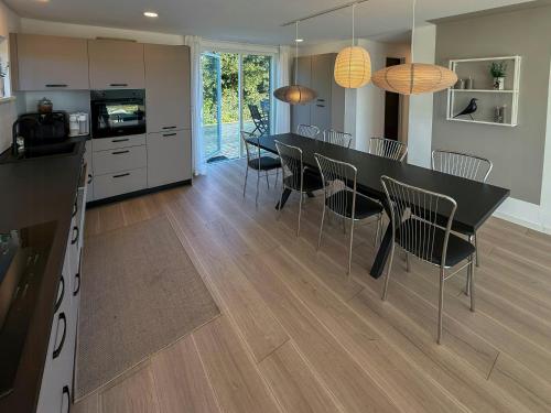 a kitchen and dining room with a table and chairs at Renovated Holiday Home With Sea View In Skåstrup in Bogense