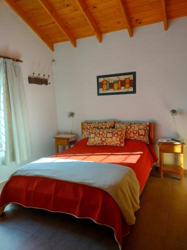 a bedroom with a large red bed in a room at Cabañas Rincon Verde in Merlo