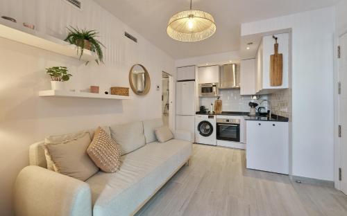 a living room with a couch and a kitchen at Sea Casa Rosa in Mijas Costa