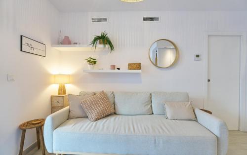 a living room with a blue couch and a mirror at Sea Casa Rosa in Mijas Costa