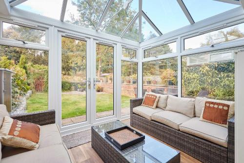 a conservatory with a couch and a table at Host & Stay - The Station Cottage in Stanley