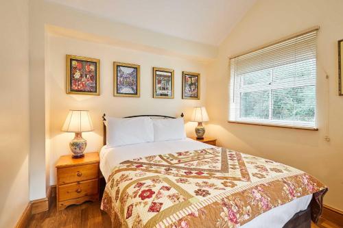 a bedroom with a bed and two lamps and a window at Host & Stay - The Station Cottage in Stanley