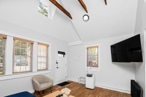 a living room with a tv and a chair at Cozy cottage close to NYC in Yonkers