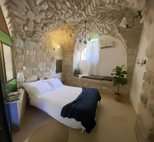 a bedroom with a large bed in a stone wall at לאה- וילה בוטנית LEAH- botanical villa in Safed