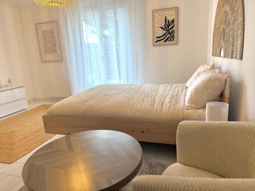 a living room with a bed and a coffee table at Le Matin bohème Paris- Orly- By Chozen in Épinay-sur-Orge