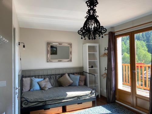 a room with a couch and a mirror and a chandelier at Maison Caramel Chalet in Landry