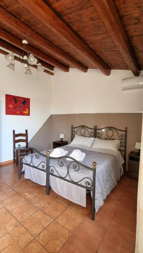 a bedroom with a large bed with a wooden ceiling at B&B Le Balate in Augusta