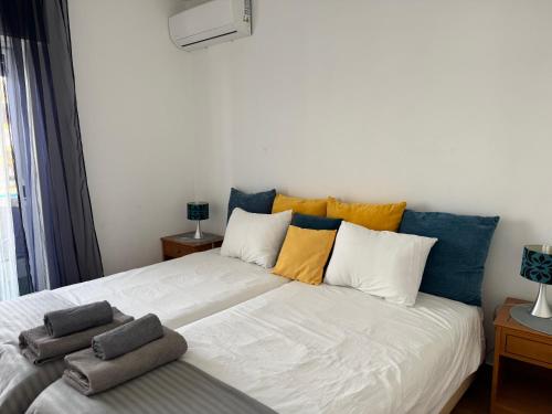 a bedroom with a large white bed with colorful pillows at Mira T1 Apartment in Carvoeiro
