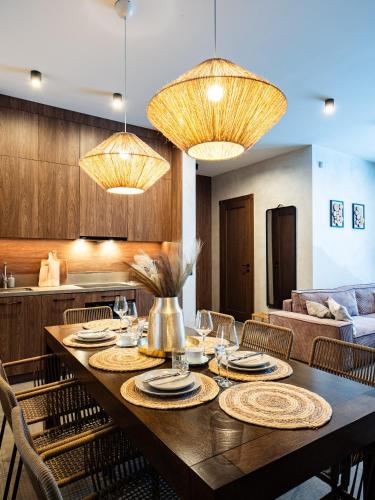 a dining room with a table with chairs and lights at LookTatry Tatra Stone House z Jacuzzi in Kościelisko