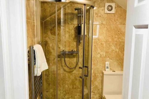 a shower with a glass door in a bathroom at Small 3 Bed Flat near Heathrow in Staines