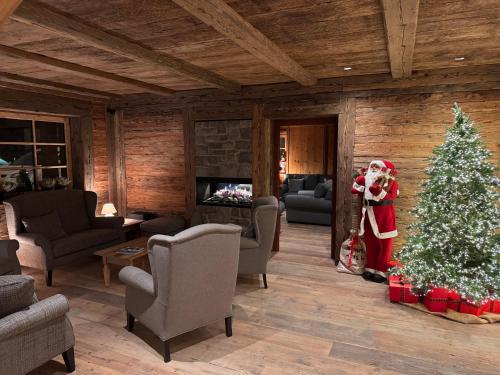 a christmas tree in a living room with a santa clause at Hotel Gran Fanes in Corvara in Badia