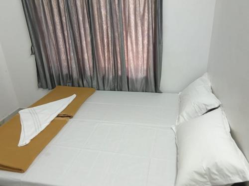 a large white bed with a window in a room at GG Residency INN in Palakkad