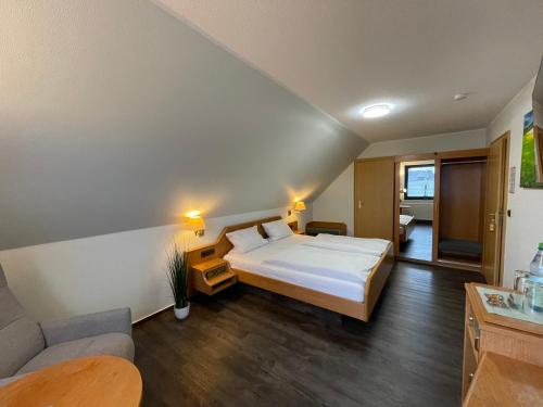 a bedroom with a large bed and a couch at Hotel Wolfsjäger in Herbern