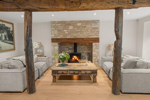 a living room with two couches and a fireplace at Arlington Mill in Bibury