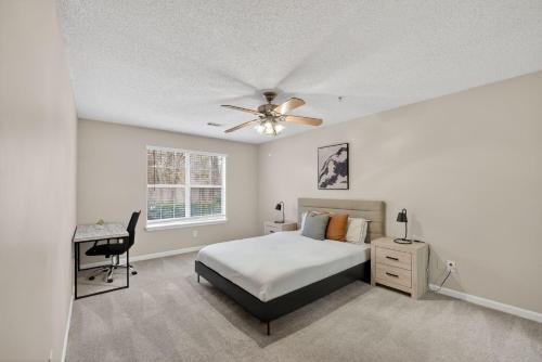 a bedroom with a bed with a ceiling fan and a desk at Stylish 2BR2BA with room to unwind in Stockbridge