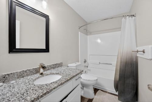 a bathroom with a sink and a toilet and a mirror at Stylish 2BR2BA with room to unwind in Stockbridge