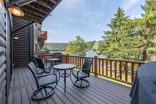 a deck with tables and chairs and a view of a lake at Cedar Shores Villa #06 by Railey Vacations in McHenry