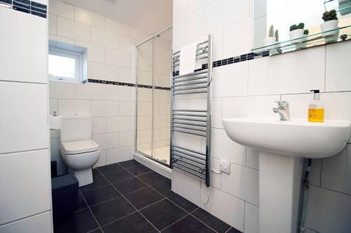 a white bathroom with a sink and a toilet at Rustic Retreat Opposite Stadium in Cardiff