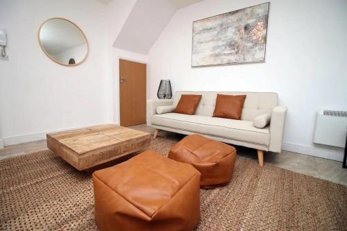 a living room with a couch and a table and a mirror at Rustic Retreat Opposite Stadium in Cardiff