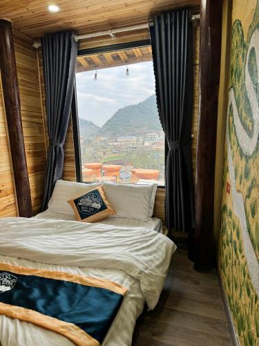 a bed in a room with a large window at Mây Đá Homestay in Loung Co