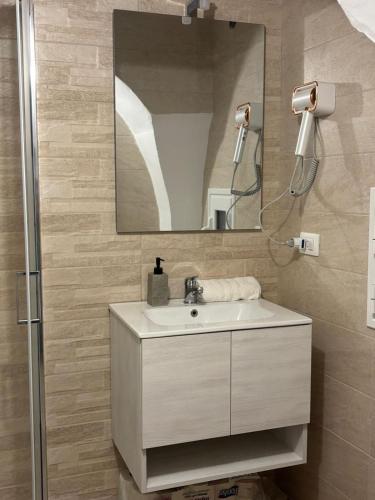 a bathroom with a sink and a mirror at Vicolo Lungo Apartment in Nardò