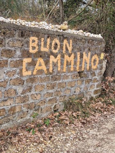 a brick wall with a sign that reads burn farming at Piccola Sorpresa Il preferito degli escursionisti sul Cammino in Scoppieto