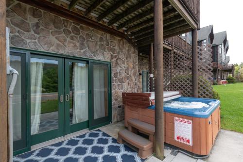 a porch with a hot tub next to a building at Cedar Shores Villa #19 by Railey Vacations in McHenry