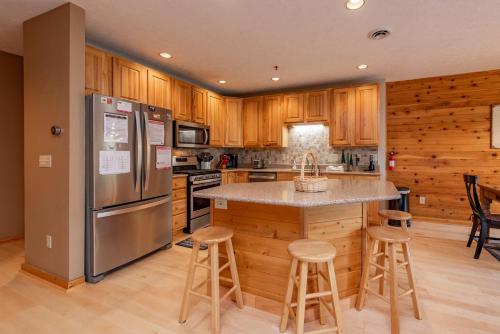 a kitchen with wooden cabinets and stainless steel appliances at Cedar Shores Villa #19 by Railey Vacations in McHenry