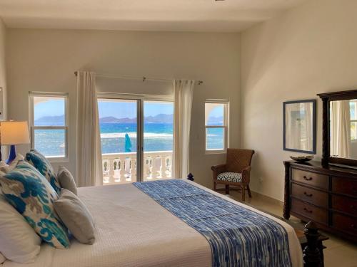 a bedroom with a bed with a view of the ocean at Lockrum Point Villa - Upscale Ocean Front, Pool with Gazebo in South Hill Village