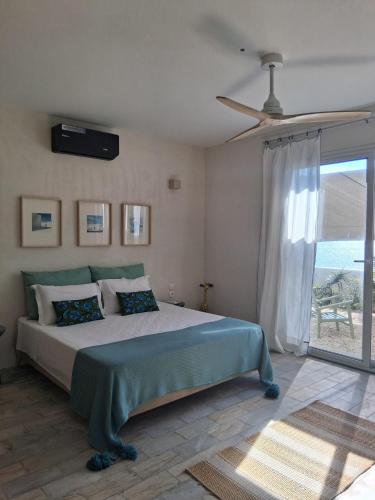 a bedroom with a bed and a large window at CasaEole B&B in El Haouaria
