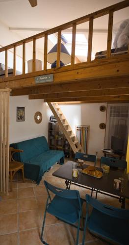 a living room with a couch and a table with chairs at Le refuge de la Fée - centre et plage in Fouras