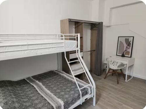 a bedroom with a bunk bed with a ladder and a desk at Charmant Cocon en duplex avec jardin in Noisy-le-Sec