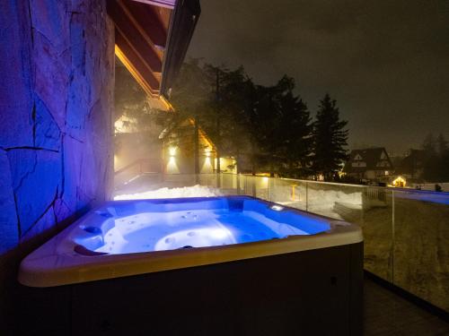 a jacuzzi tub with blue lighting in a room at LookTatry Tatra Stone House z Jacuzzi in Kościelisko
