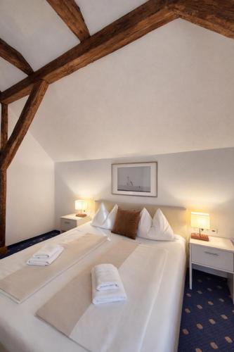 białe łóżko z dwoma ręcznikami na nim w obiekcie Stadthotel Kramer w Villach