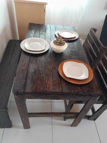 a wooden table and chairs with plates on it at Dudes guesthouse in Francistown