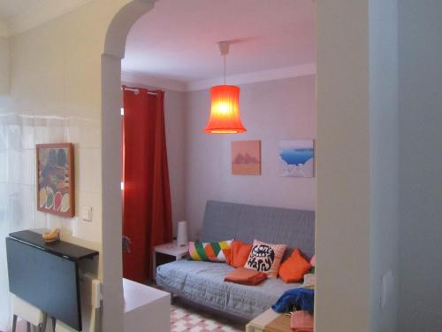 sala de estar con sofá azul y cortina roja en Casa das Bonecas en Vila Real de Santo António